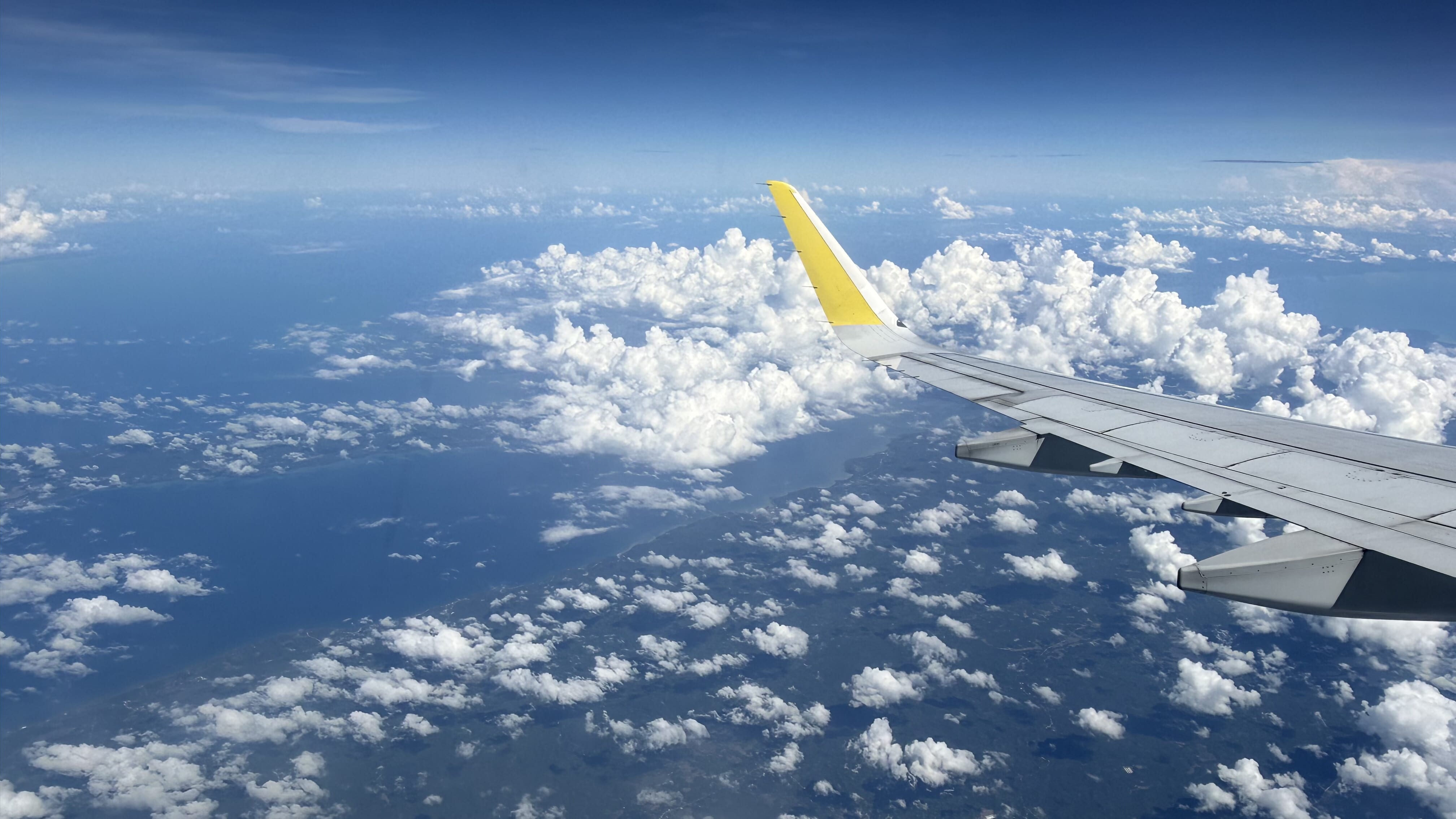 一人旅行に向かう途中の、飛行機の窓から見下ろす雲の景色